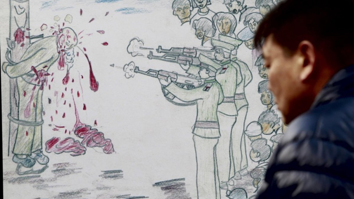 A Sourth Korean man looks at a caricature depicting a public execution in North Korea, during a rally against North Korea's human rights policy in Seoul, South Korea. Photo by JEON HEON-KYUN / EPA