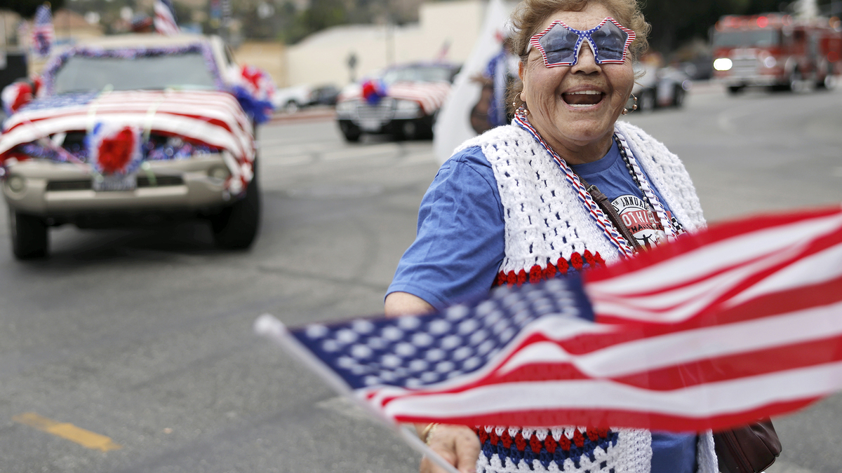 A participant waves an American flag during the 67th annual El Sereno Independence Day Parade in the predominantly Latino community of El Sereno on June 27, 2026 in Los Angeles, California. This year's theme was "100 Years of Route 66" and the parade was cancelled last year due to safety concerns amid widespread ICE raids across the city. People around the nation are gearing up for America's 250th anniversary, which will be marked on July 4, 2026, commemorating the signing of the Declaration of Independence. (Mario Tama/Getty Images/TNS)