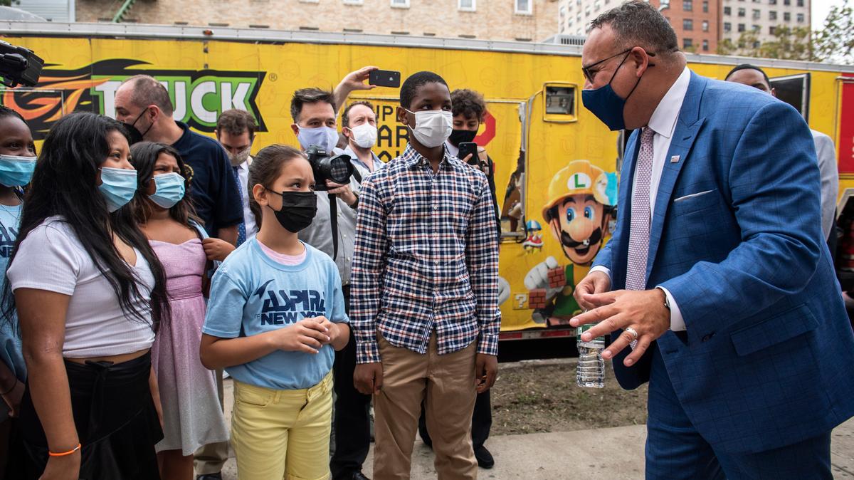 Education Secretary Miguel Cardona speaks to students outside P.S. 5 Port Morris, a Bronx elementary school in New York, Tuesday, Aug. 17, 2021.