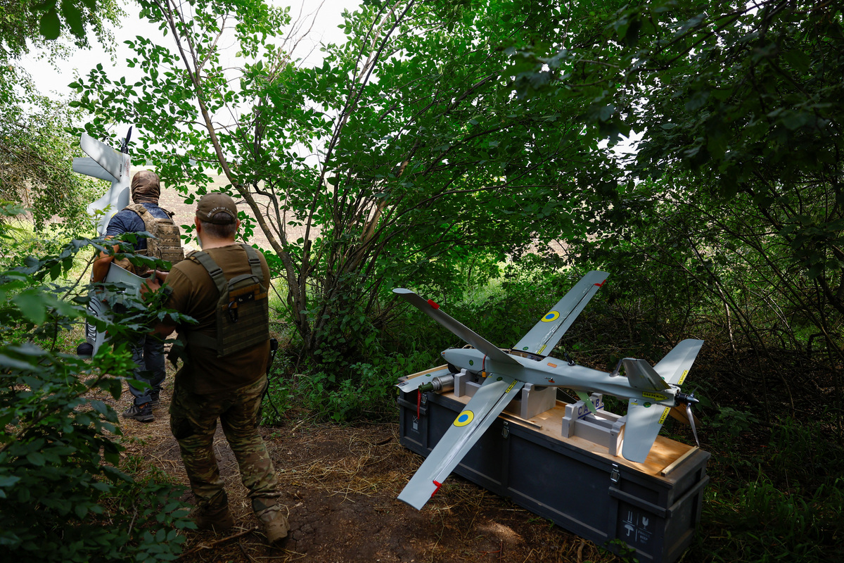 Service members of the 422nd Unmanned Systems Regiment 'Luftwaffe' of the Ukrainian Armed Forces, carry a Shark reconnaissance drone to a launch point while they work at a position near a front line, amid Russia's attack on Ukraine, in an undisclosed location in Southern Ukraine, on an undisclosed date, 2026. REUTERS/Valentyn Ogirenko