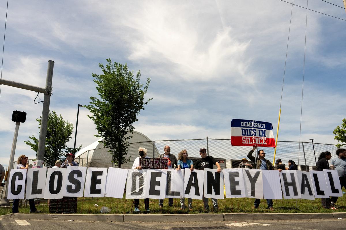 Demonstrators hold placards next to a road block leading to Delaney Hall, in Newark, New Jersey, U.S., May 31, 2026. REUTERS/David 'Dee' Delgado