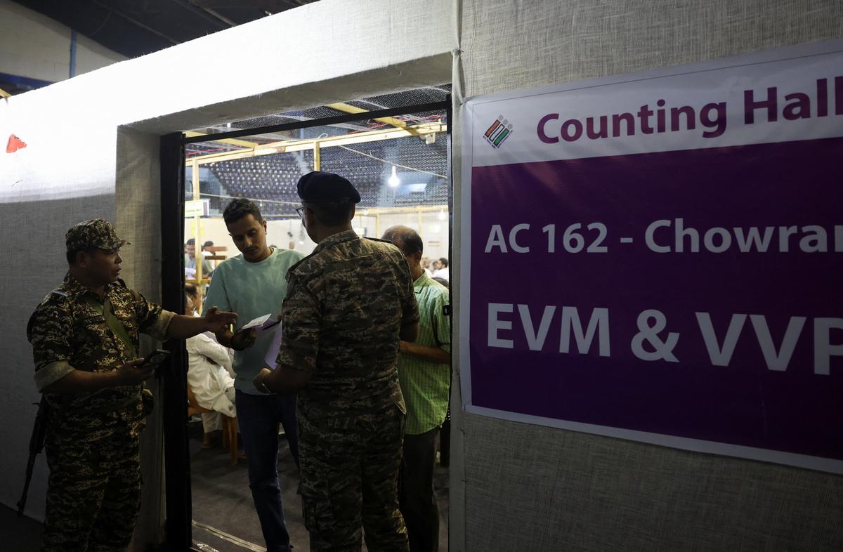 Security personnel check the identification of election officials during vote counting of the West Bengal Legislative Assembly election polls inside a counting centre in Kolkata, India, May 4, 2026. REUTERS/Sahiba Chawdhary