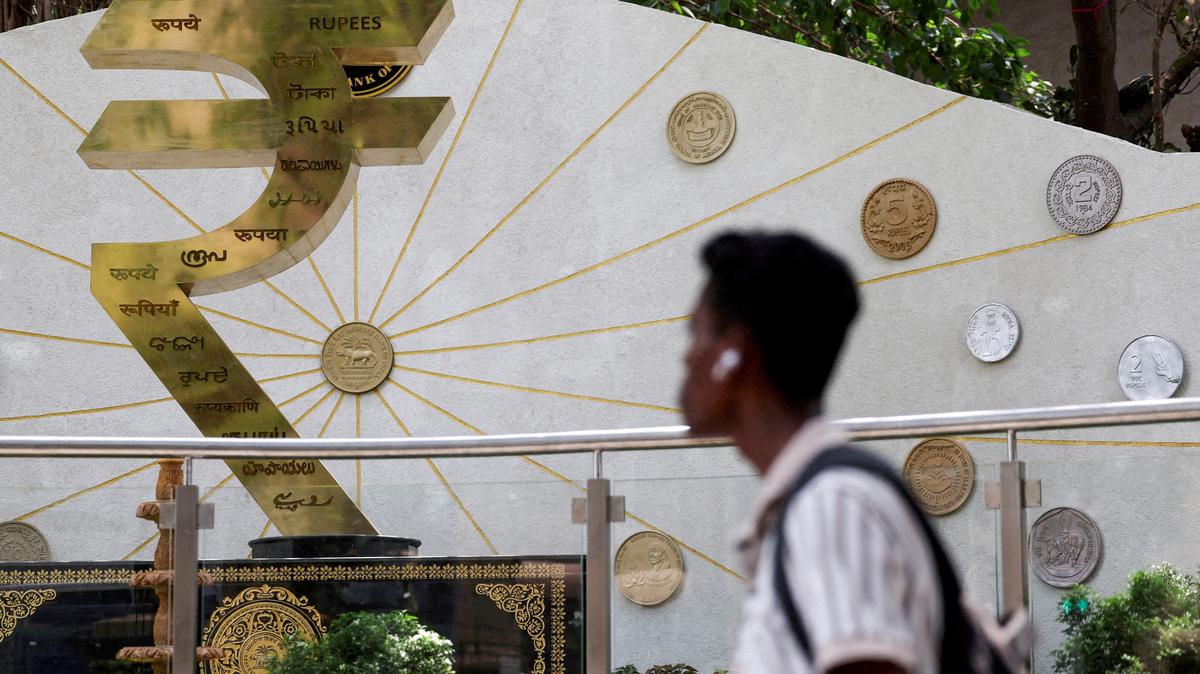 FILE PHOTO: A man walks past an installation of the Rupee logo and Indian currency coins outside the Reserve Bank of India (RBI) headquarters in Mumbai, India, April 9, 2025. REUTERS/Francis Mascarenhas//File Photo