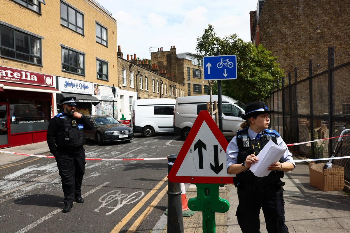 Police Community Support Officer (PCSO) and a Metropolitan Police Officer work at the scene of a suspected arson attack on a former synagogue in London, Britain, May 5, 2026. REUTERS/Jack Taylor