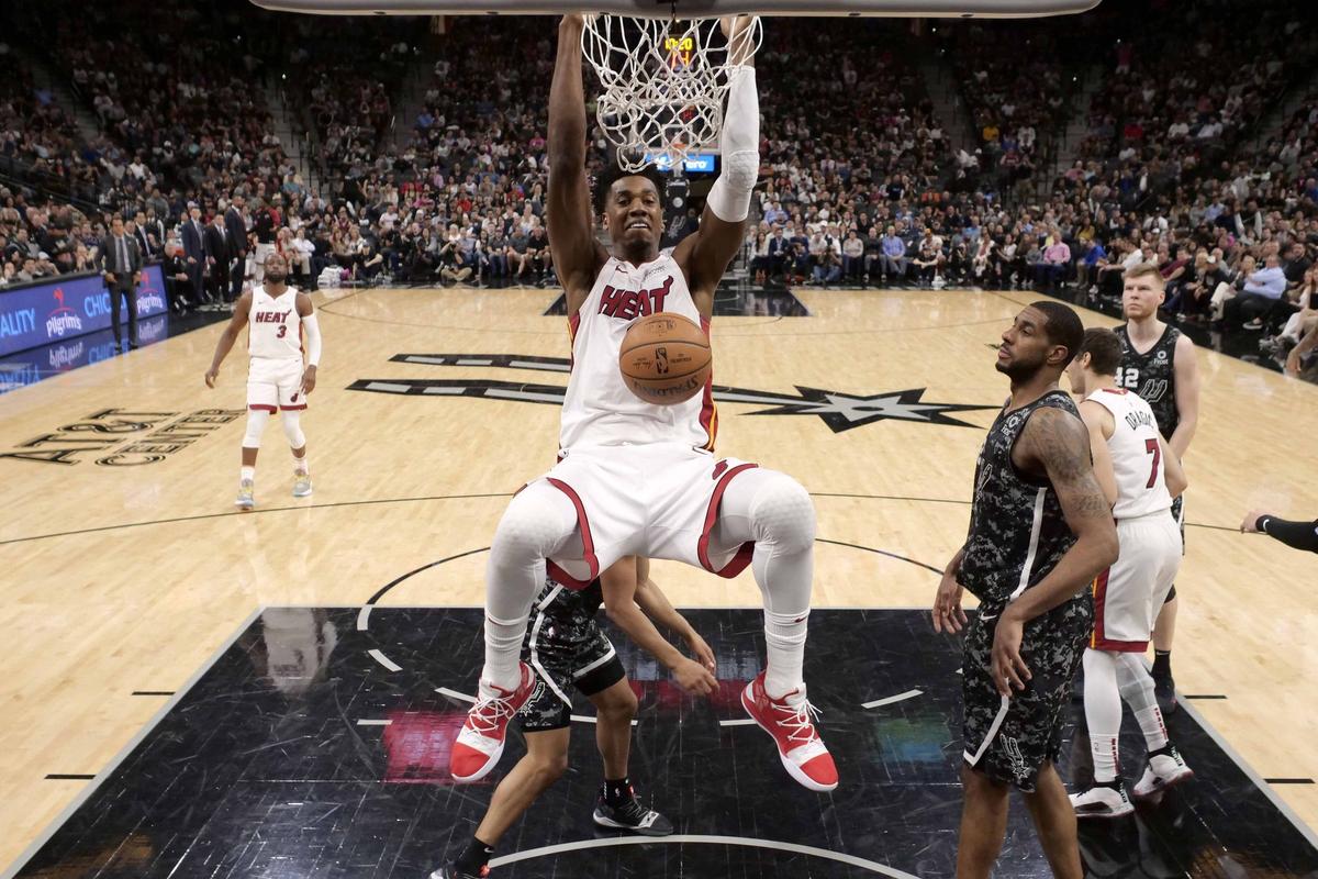 Mar 20, 2019; San Antonio, TX, USA; Miami Heat center Hassan Whiteside (21) dunks the ball past San Antonio Spurs shooting guard Bryn Forbes (behind) during second half at AT&T Center. Mandatory Credit: Soobum Im-USA TODAY Sports