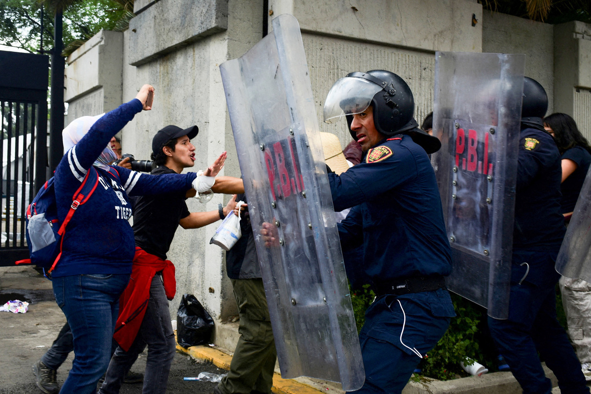 Demonstrators scuffle with riot police during a protest outside the Azteca Stadium during the opening match of the 2026 FIFA World Cup in Mexico City, Mexico, June 11, 2026. REUTERS/Rolando Ramos