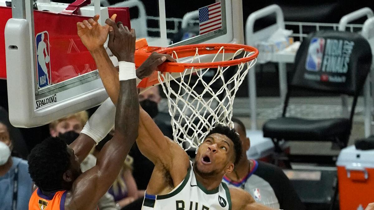Giannis Antetokounmpo, de los Bucks (34), bloquea al centro de los Sunns Deandre Ayton (22) en el Juego 4 de las Finales de la NBA en Milwaukee, el 14 de julio de 2021.