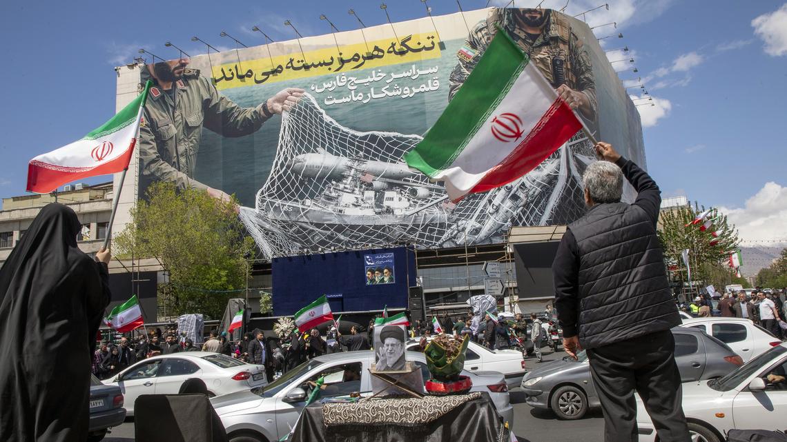 Iranians hold national flags as they gather in Tehran's Revolution Square after the United States and Iran agreed to a two-week ceasefire, on April 8, 2026 in Tehran, Iran. The United States and Iran agreed to a two-week ceasefire barely an hour before the US president's April 8 deadline to obliterate the country, triggering global relief alongside apprehension. (Majid Saeedi/Getty Images/TNS)