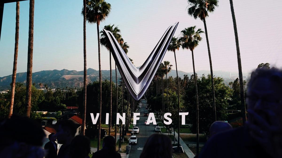 People walk next to a VinFast logo on a screen during the press day at the Los Angeles Auto Show in Los Angeles, California, U.S. November 17, 2022. REUTERS/Mike Blake