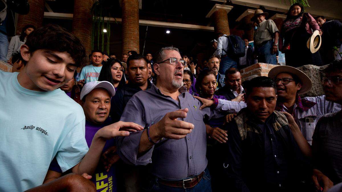 El candidato presidencial por el Movimiento Semilla, Bernardo Arévalo, está rodeado de partidarios cuando sale del Hotel Casablanca en Huehuetenango, donde se reunió con líderes locales y realizó una conferencia de prensa el 12 de agosto de 2023, durante el último tramo de su campaña antes de la segunda vuelta electoral el 20 de agosto de 2023 contra Sandra Torres.