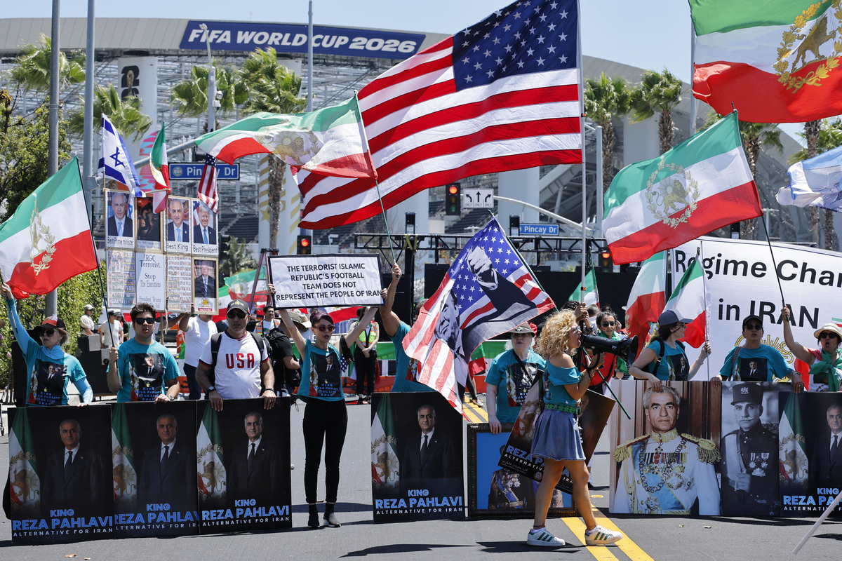 Supporters of Iranian political activist Reza Pahlavi protest outside Los Angeles Stadium in Inglewood, Calif., on Monday before Iran’s World Cup opening match with New Zealand. Many Iranian American demonstrators carried pre-revolutionary flags - the lion‑and‑sun emblem used before 1979 and now a symbol of protest.