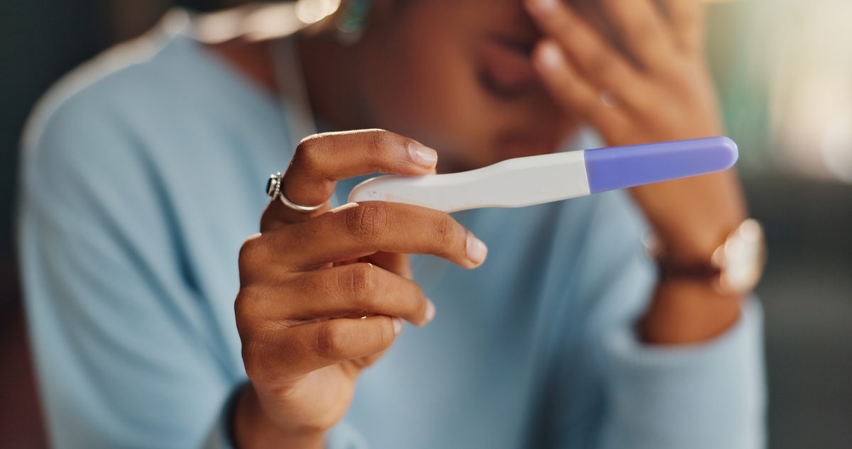  A woman holds a pregnancy test. “Pregnancy was presented not as something extraordinary and unique to the female body, but as a lethal consequence to avoid at all costs,” writes Isabel Brown. 