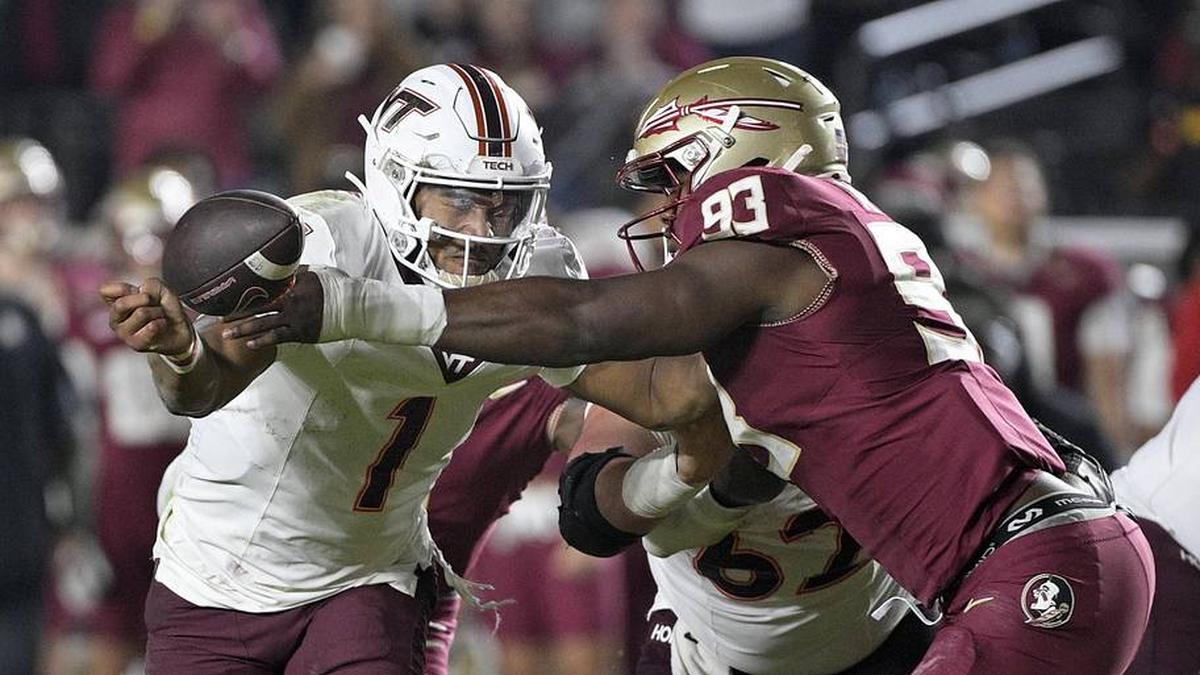  Nov 15, 2025; Tallahassee, Florida, USA; Virginia Tech Hokies quarterback Kyron Drones (1) has the ball knocked away by Florida State Seminoles defensive lineman Mandrell Desir (93) during the second half at Doak S. Campbell Stadium. Mandatory Credit: Melina Myers-Imagn Images | Melina Myers-Imagn Images 