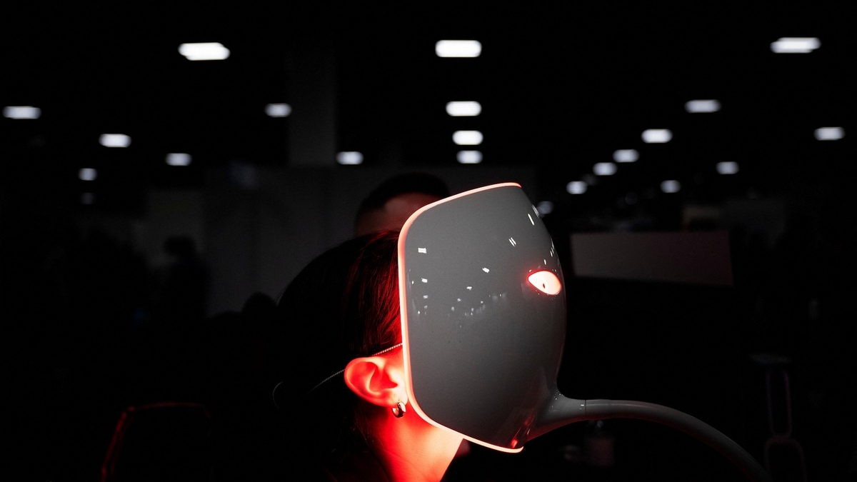 A person uses a red light mask from Lucibel.le Paris at the Venetian Expo Center during the Consumer Electronics Show (CES) in Las Vegas, Nevada, on January 11, 2024. (Photo by Brendan Smialowski / AFP)