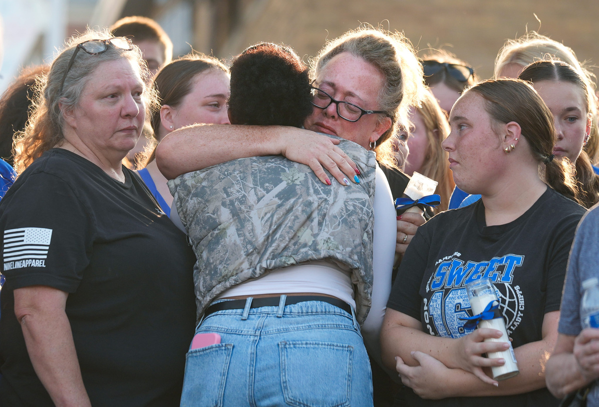 Loved ones hug one another as they mourn the loss of Rittman Police Sgt. Scott Ries during a candlelight vigil held in front of the police station, July 6, 2026, in Rittman, Ohio.