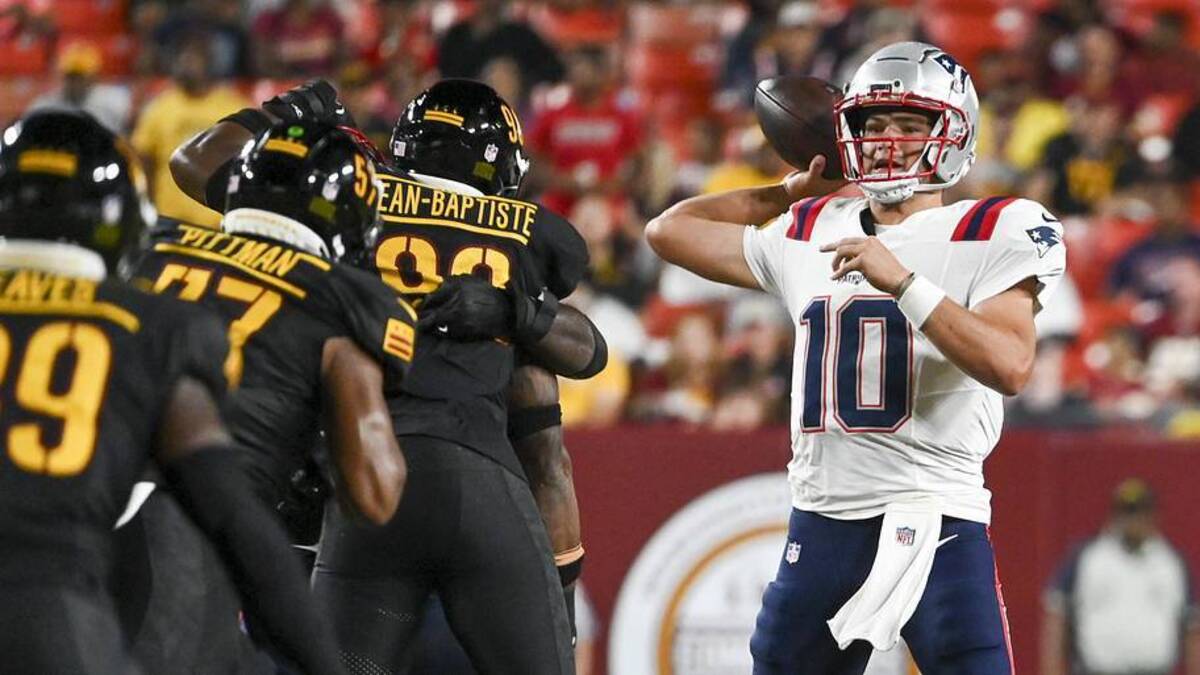 Aug 25, 2024; Landover, Maryland, USA; New England Patriots quarterback Drake Maye (10) throws off his back foot as Washington Commanders defense applies pressure during the first half at Commanders Field. Mandatory Credit: Tommy Gilligan-Imagn Images | Tommy Gilligan-Imagn Images 