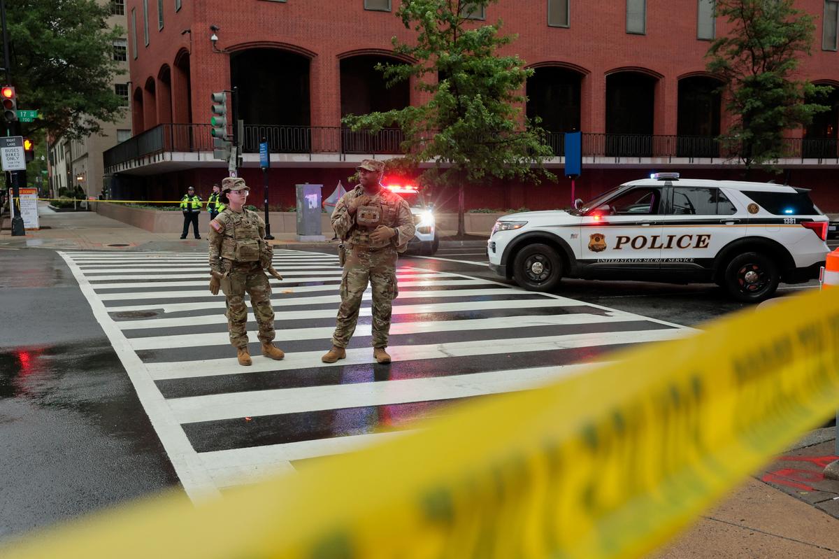 Members of the U.S. National Guard stand behind yellow tape cordoning an area near the White House after alleged gunshots were heard nearby, in Washington, D.C., U.S., May 23, 2026. REUTERS/Kylie Cooper