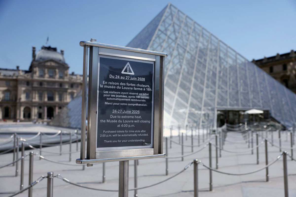 A sign which reads "Due to extreme heat, the Musee du Louvre will close at 4 pm" is seen at the entrance of the glass Pyramid of the Louvre museum as the museum closes early due to the heatwave as temperatures rise in Paris, France, June 24, 2026. REUTERS/Alice Sacco