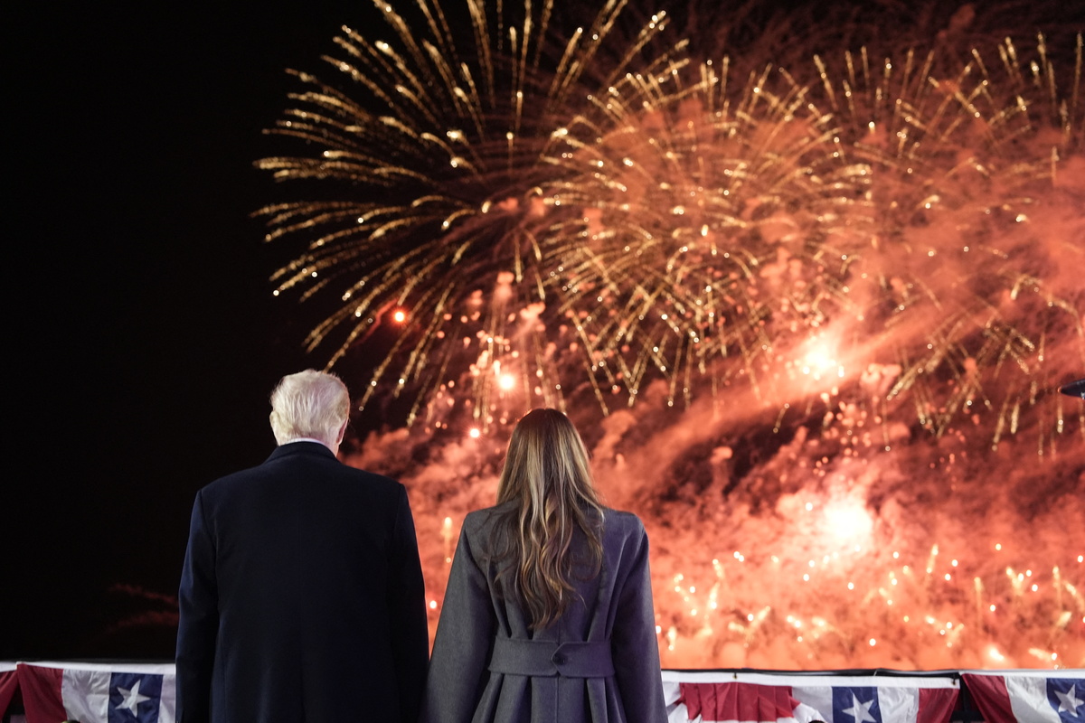  US President-elect Donald Trump and his wife Melania Trump stand to watch fireworks during a reception in his honor at Trump National Golf Club Washington DC in Sterling, Virginia, on January 18, 2025. 