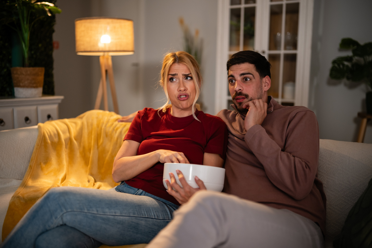  A stock image of a young couple watching TV at home. 