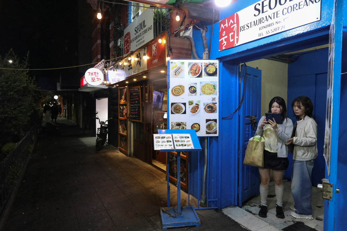 South Koreans stand at the entrance of Seoul restaurant in Little Seoul, as the bond between Korea and Mexico is one of the world’s more unusual geo‑cultural love stories, with Korean influence gaining a foothold despite distance, language and a 15-hour time difference, in Mexico City, Mexico June 17, 2026. REUTERS/Paola Garcia