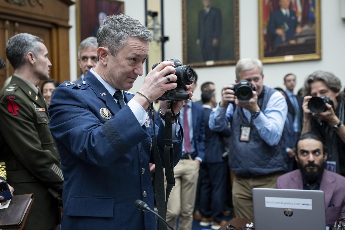 Gen. Dan Caine, chairman of the Joint Chiefs of Staff, borrows a camera from a photojournalist before he testified during a House Armed Services Committee hearing on the Department of Defense's budget request on Capitol Hill in Washington, on Wednesday, April 29, 2026. (Haiyun Jiang/The New York Times)