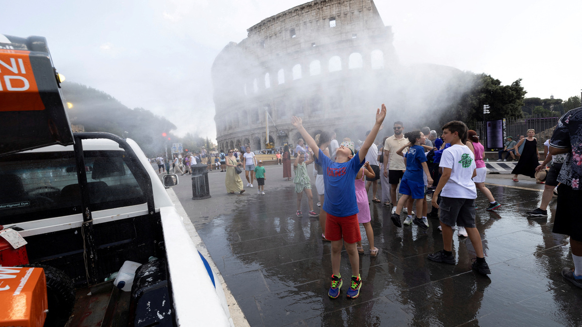 People cool off under a water mist near the Colosseum as Italy’s Civil Protection deploys measures to help residents and tourists cope with a heatwave, in Rome, Italy, June 26, 2026. REUTERS/Remo Casilli