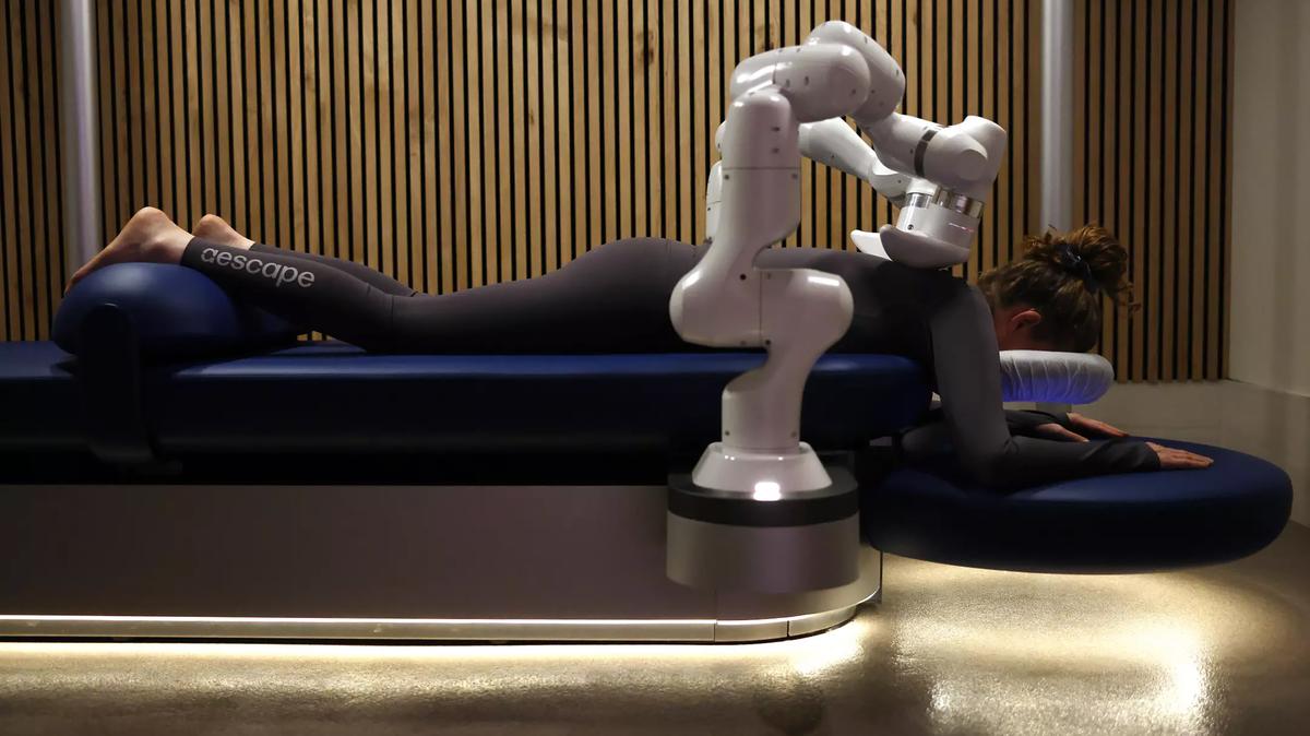 Reporter Deborah Vankin tries out the Aescape massage robot at Pause Wellness Studio in 2024. (Christina House/Los Angeles Times/TNS)