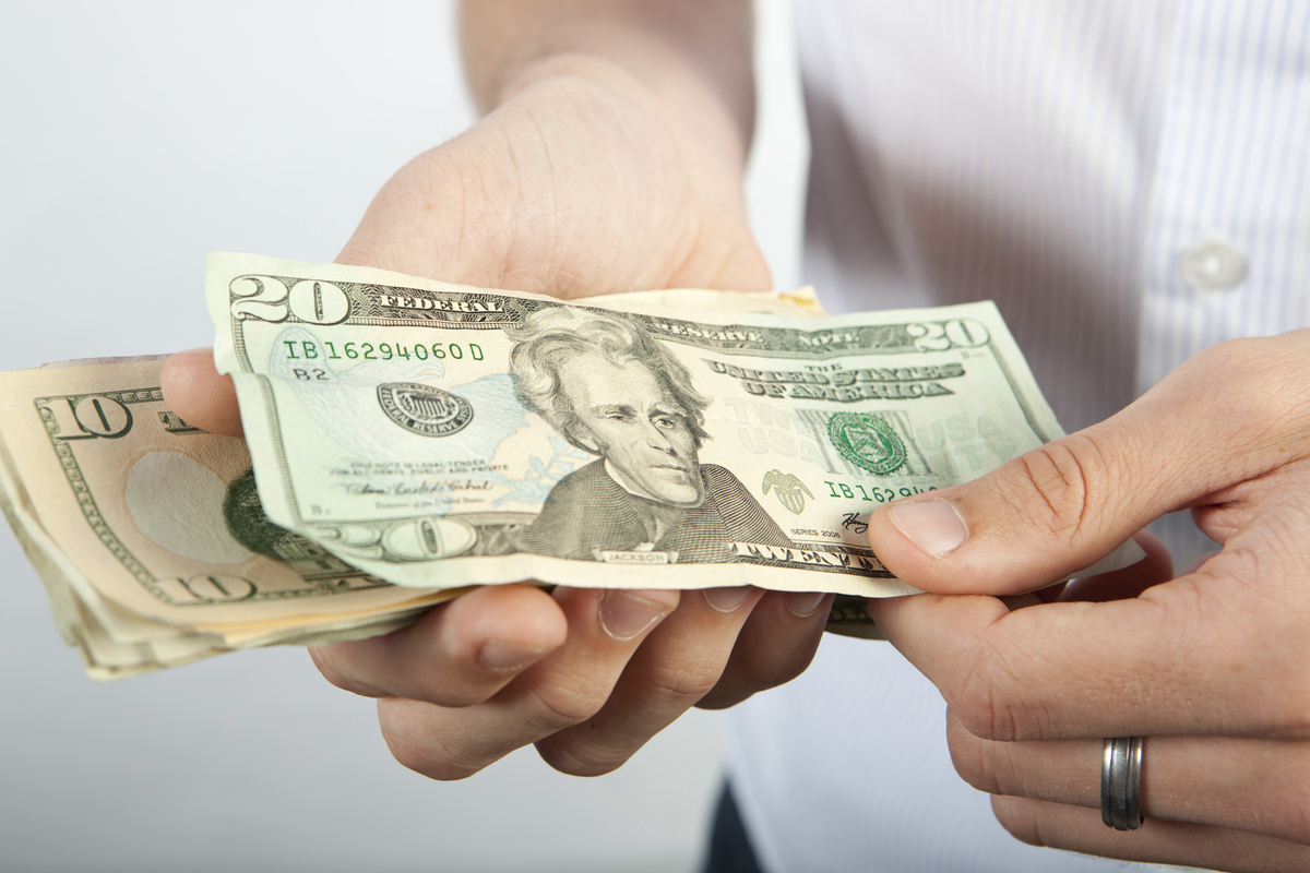  A man is seen counting various denominations of U.S. dollars. (Newscast Limited via AP Images) 