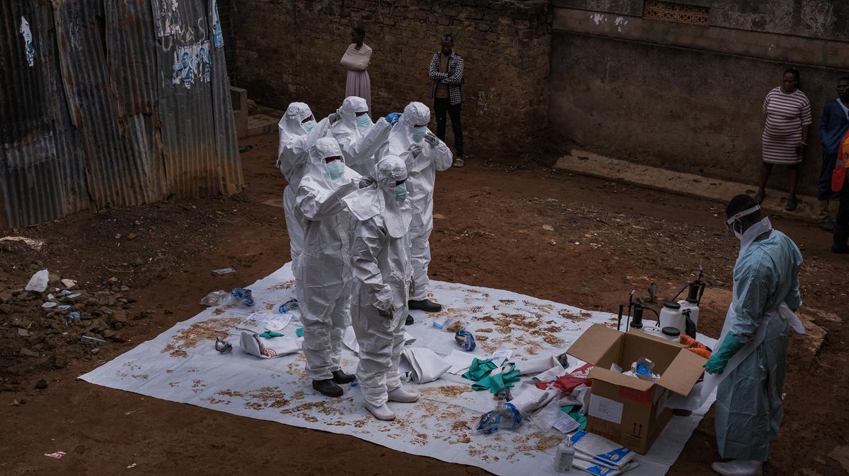 Workers from the Uganda Red Cross Society don protective suits as they prepare to evacuate the body of a suspected Ebola victim in Kampala on May 26, 2026. The organization is poised to assist the Ministry of Health in transporting suspected cases to treatment centers and conducting safe, dignified burials following confirmed positive results. This action comes after the confirmation of three additional Ebola Bundibugyo cases, raising the total to five linked to travelers from the neighboring Democratic Republic of Congo (DRC), where an outbreak has claimed 119 lives among 904 suspected cases. The World Health Organization has classified this outbreak in both the DRC and Uganda as a public health emergency of international concern. (Badru Katumba/AFP via Getty Images/TNS)