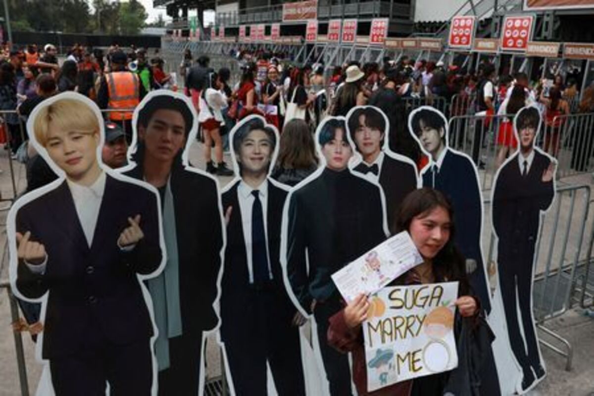 FILE PHOTO: A fan poses with cardboard cutouts as they gather outside the venue before South Korean Kpop boy band BTS's concert, as the bond between Korea and Mexico, one of the world’s more unusual geo-cultural connections, continues to grow, with Korean influence gaining a foothold despite distance, language barriers and a 15-hour time difference, in Mexico City, Mexico, May 7, 2026. REUTERS/Henry Romero/File Photo