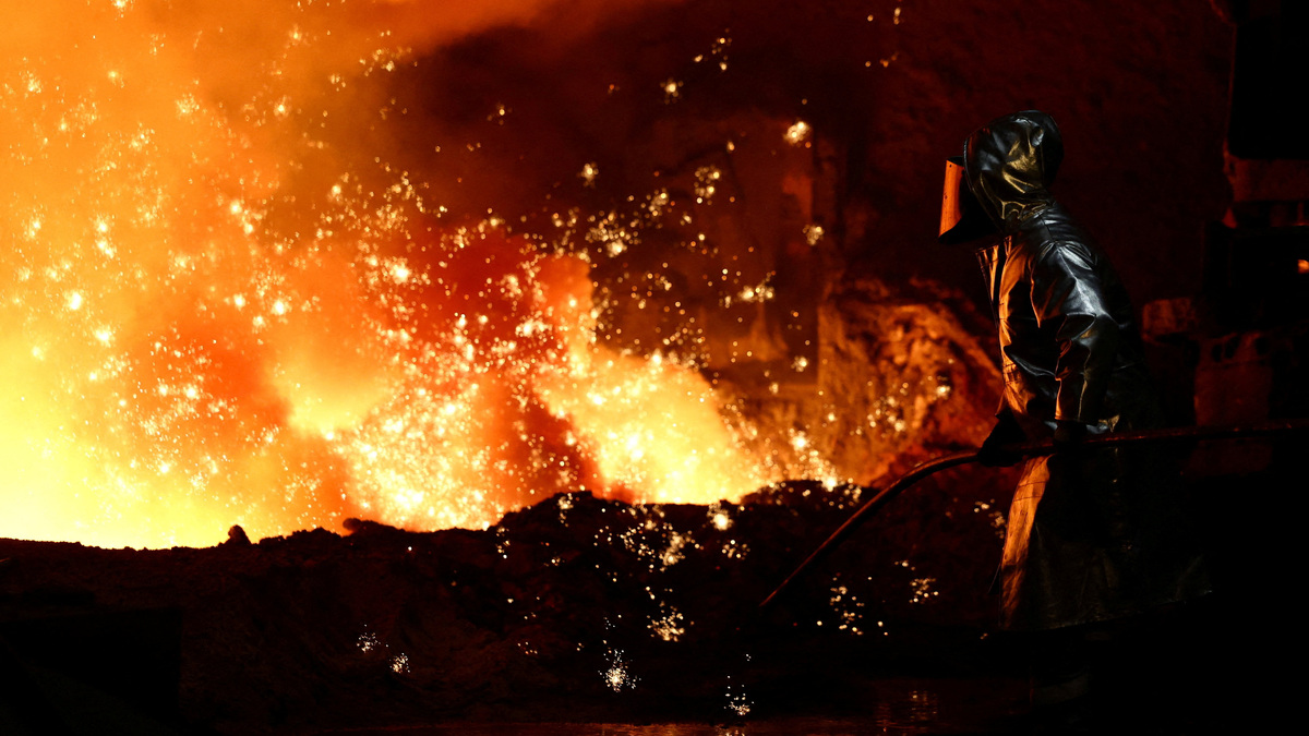 A steel worker stands amid sparks of raw iron coming from a blast furnace at a ThyssenKrupp steel factory in Duisburg, Germany, November 5, 2025. REUTERS/Leon Kuegeler