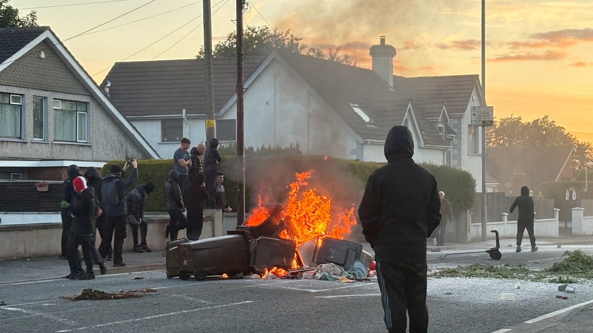 A fire burns in bins as anti-immigrant protesters clash with police at Antrim road, following a knife attack on June 8, which left a man seriously injured and prompted police to declare a critical incident, in Belfast, Northern Ireland, June 10, 2026. Picture taken with a phone. REUTERS/Isabel Infantes