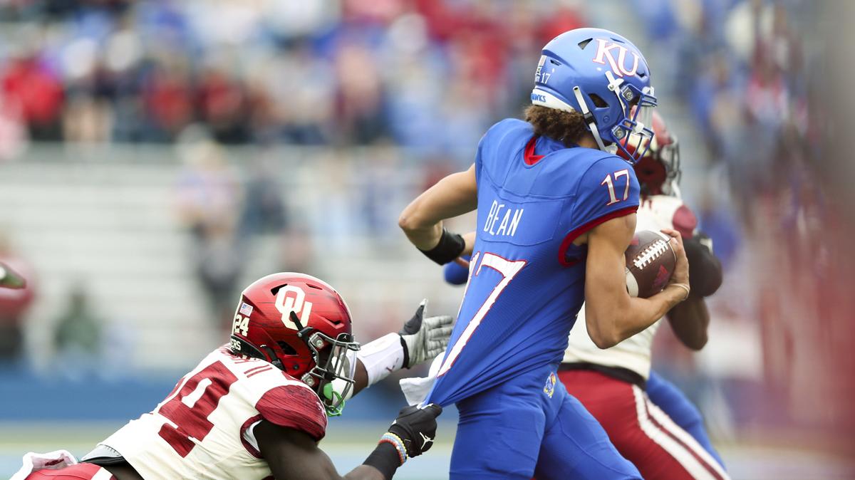Oklahoma linebacker Brian Asamoah (24) attempts to tackle Kansas quarterback Jason Bean (17) during an NCAA college football game, Saturday, Oct. 23, 2021, in Lawrence, Kan. (Ian Maule/Tulsa World via AP)
