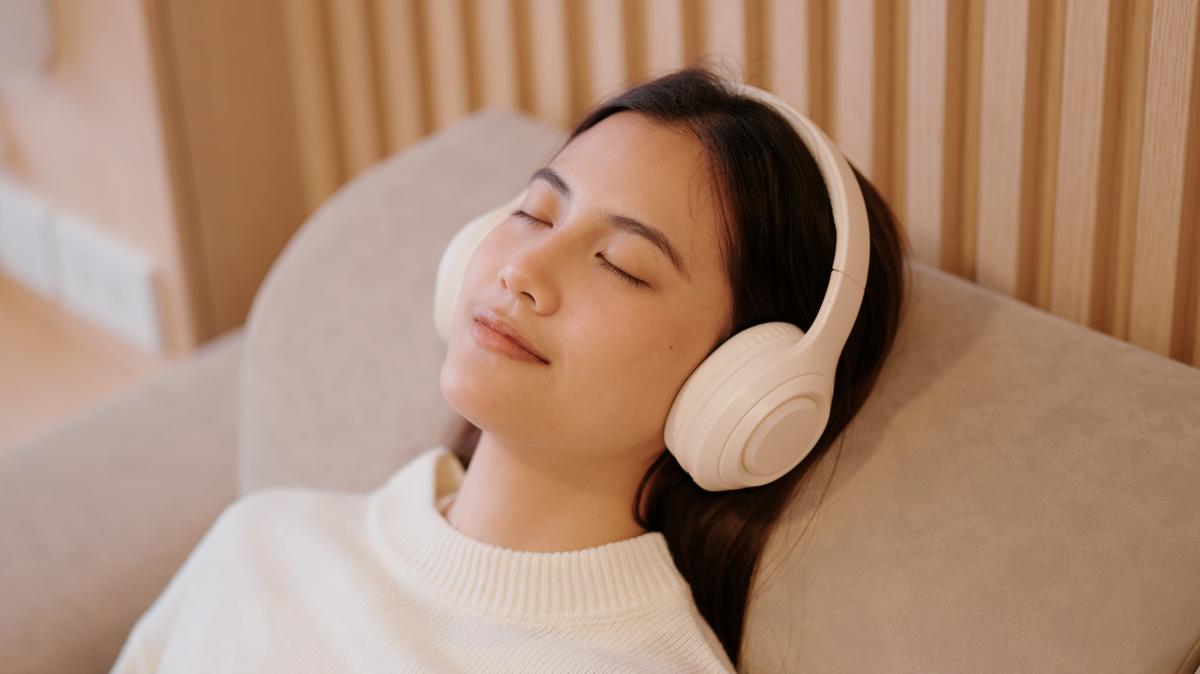 Taking a relaxing nap on a comfy sofa with wireless headphones.