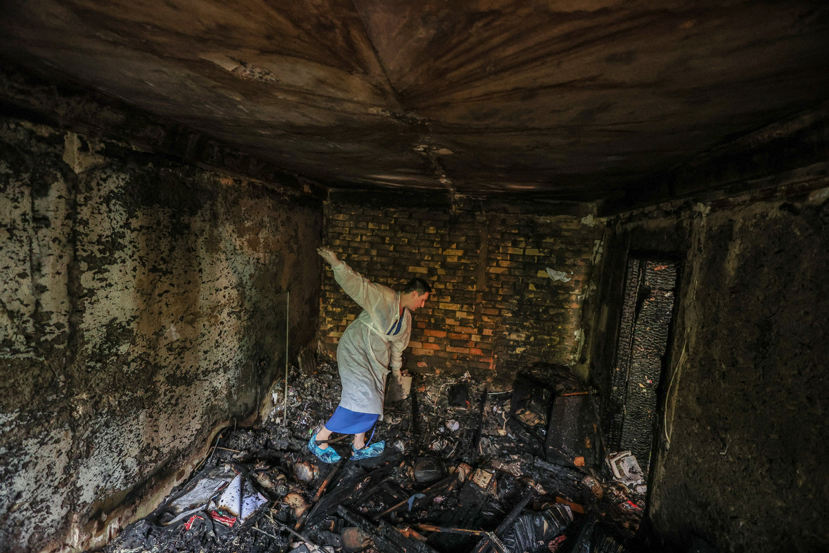 Iryna Plekhova, 42, resident who survived yesterday's Russian missile and drone attack, looks for her remaining personal belongings in the burned down apartment, which was damaged during the strike, amid Russia's attack on Ukraine, in Kyiv, Ukraine July 3, 2026. REUTERS/Alina Smutko