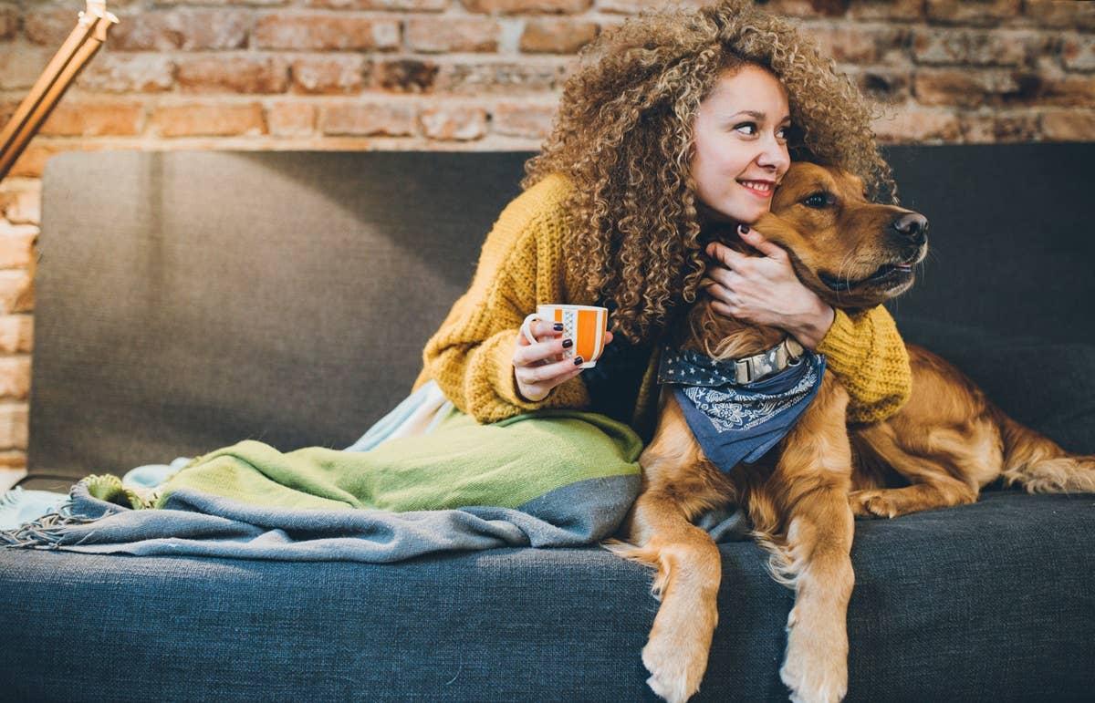  A woman trying to hug her uninterested dog.