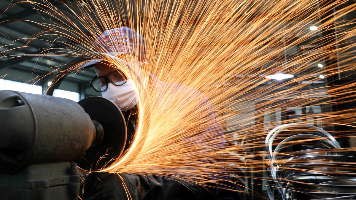 FILE PHOTO: A worker wearing a face mask works on a production line manufacturing bicycle steel rim at a factory, as the country is hit by the novel coronavirus outbreak, in Hangzhou, Zhejiang province, China March 2, 2020. China Daily via REUTERS/File Photo