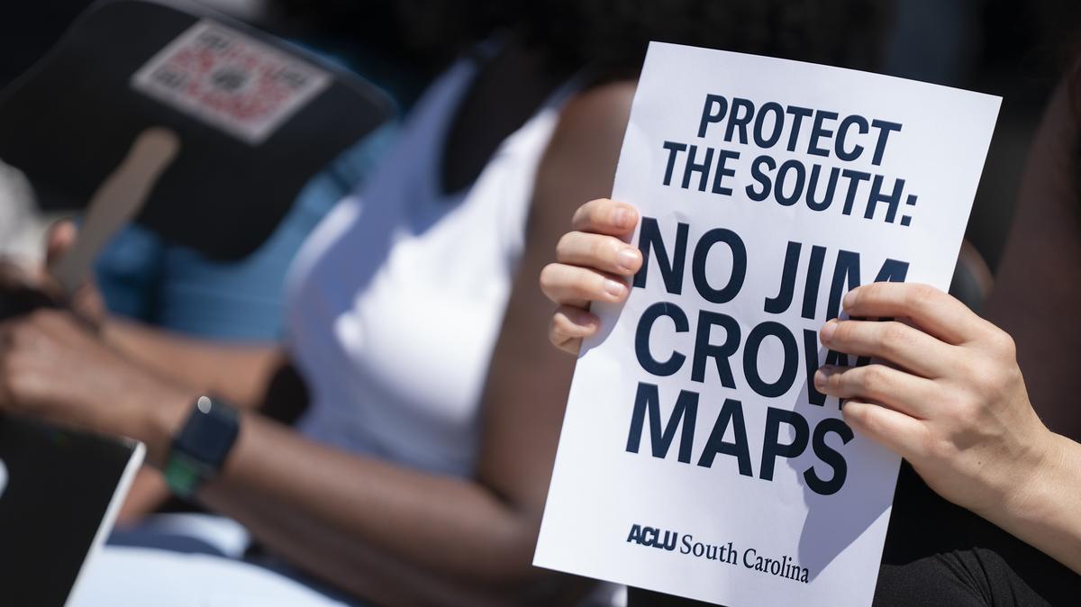 A demonstrator holds a sign on the statehouse steps during a rally in opposition to congressional redistricting on May 14, 2026, in Columbia, S.C. South Carolina Gov. Henry McMaster announced a special session on redistricting that could potentially dismantle Democratic held districts. Early voting for the midterm statewide primary starts on May 26.