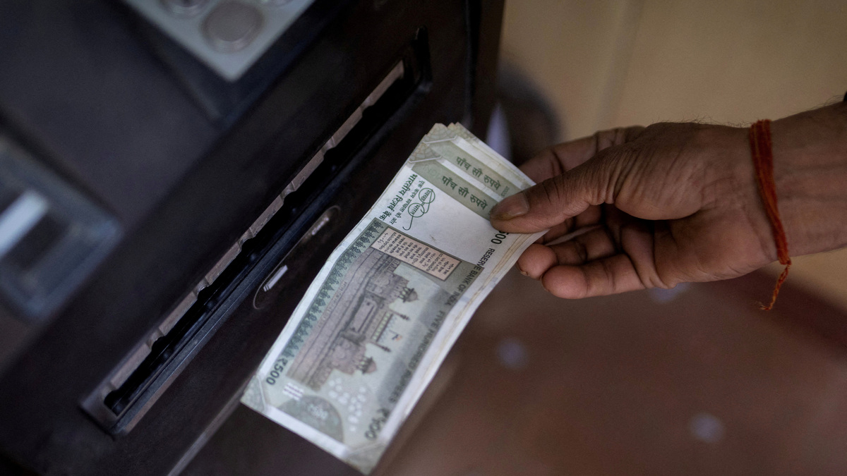 FILE PHOTO: A man withdraws money from an automated teller machine (ATM) in New Delhi, India, April 3, 2025. REUTERS/Adnan Abidi/File Photo