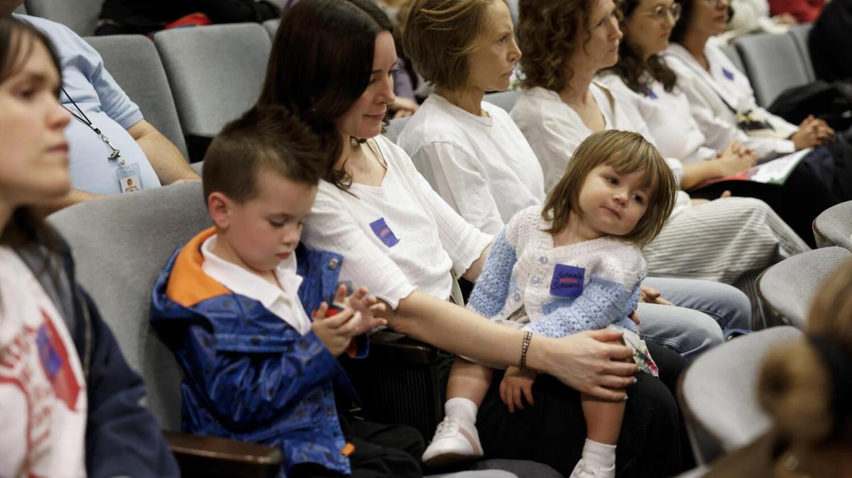 Dean Oberlin, 4, left, sits next to his mother, Carly Oberlin, center, and sister, Peggy Oberlin, 1, right, during a board meeting at the Los Angeles Unified School District headquarters on Tuesday, April 21, 2026, in Los Angeles, CA. The LAUSD met to discuss a resolution calling for development of a Screen Time Policy setting time limits by grade, including elimination of student digital devices for early education through first-grade, prohibiting device use by elementary and middle school students during passing periods, lunch and recess. The board unanimously voted to approve Board Member Nick Melvoin's Resolution to limit student screen time. (Kayla Bartkowski/Los Angeles Times/TNS)