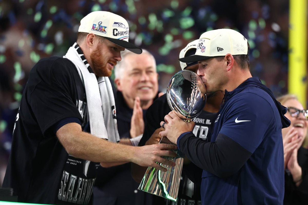  Feb 8, 2026; Santa Clara, CA, USA; Seattle Seahawks head coach Mike MacDonald and quarterback Sam Darnold (14) celebrate with the Vince Lombardi trophy on the podium after defeating the New England Patriots in Super Bowl LX at Levi's Stadium. Mandatory Credit: Mark J. Rebilas-Imagn Images 