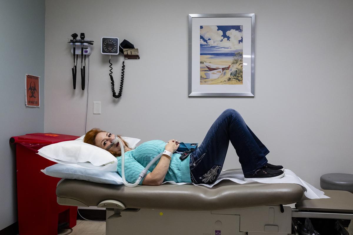Amanda Sifford rests after the spinal infusion in Miami on Jan. 9, 2026. She uses a portable noninvasive ventilator in situations where she needs breathing support, but has been able to use it less often since starting tofersen. (Eva Marie Uzcategui/The New York Times)