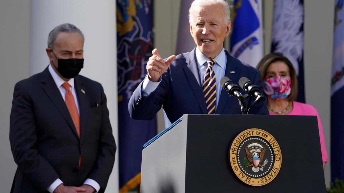 El presidente Joe Biden da un discurso sobre los beneficios del Plan de Rescate Americano, un paquete de estímulo económico para mitigar los efectos de la pandemia, el viernes 12 de marzo de 2021 en El Jardín de las Rosas de la Casa Blanca, Washington D.C. Lo acompañan la presidenta del Congreso, Nancy Pelosi, y el líder de la mayoría en el Senado, Chuck Schumer.