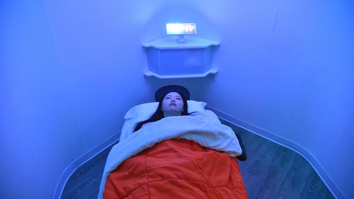 Laura Li prepares to take a nap in YeloSpa, in New York, on May 1, 2018,where New Yorkers can pay for a cabin to take a nap, and recharge energy without having to return to their homes. In New York, a city constantly on the go, with arduous commutes and ultra-competitive jobs, instead of knocking back a coffee or quaffing an energy drink, a growing number of people are opting for a quick nap during office hours. (Photo by Hector RETAMAL / AFP) / With AFP Story by Laura BONILLA:  Learning to nap in New York, city that never sleeps
