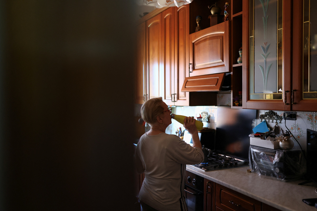 Dina Gazzella, 85, drinks water in her kitchen in Rome, Italy, June 26, 2026. Gazzella wears an electronic bracelet that monitors her heart rate and sleep patterns, allows her to call for help in an emergency, and enables a team of social workers to monitor her remotely. The device is part of a support scheme for the elderly introduced last year by Rome's municipality, which local authorities describe as an important preventive healthcare tool, particularly during the Europe-wide heatwave that has pushed temperatures in Rome above 30 degrees Celsius. REUTERS/Yara Nardi