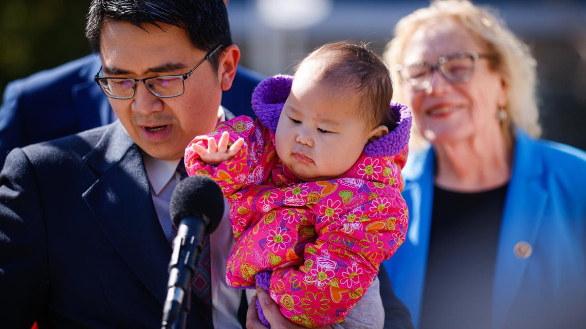 Hoang Truong, of San Jose, speaks while holding his daughter Joann Truong, 11 months, during a press conference at Valley Medical Center in San Jose, Calif., on Tuesday, March 18, 2025. Without Medi-Cal, he would be spending half his family’s income on health insurance. (Shae Hammond/Bay Area News Group)