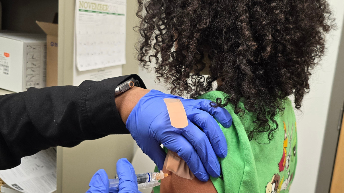 A child receives one of two vaccinations for flu and COVID-19 at the Cumberland County Department of Public Health in Fayetteville, NC.