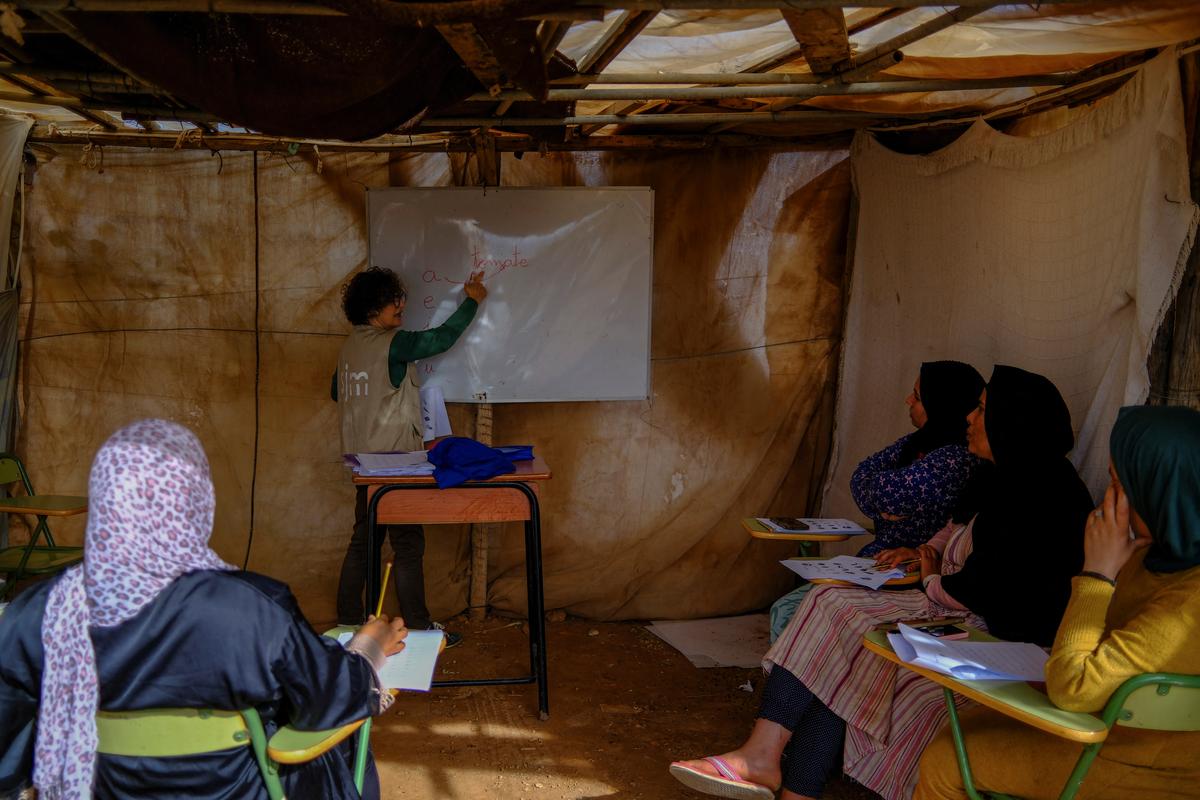 Undocumented migrants from Morocco attend Spanish classes taught by members of the Jesuit Migrant Service in a shanty town after returning of their work inside a plastic-covered greenhouse in Almeria province, home to Europe’s largest concentration of agricultural greenhouses, in Nijar, Spain, May 5, 2026. Undocumented migrants there live without reliable electricity and with limited access to water. REUTERS/Nacho Doce