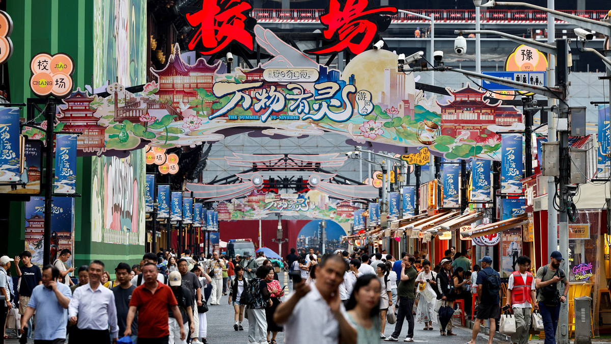 People walk along a shopping street in Shanghai, China, July 1, 2026. REUTERS/Go Nakamura